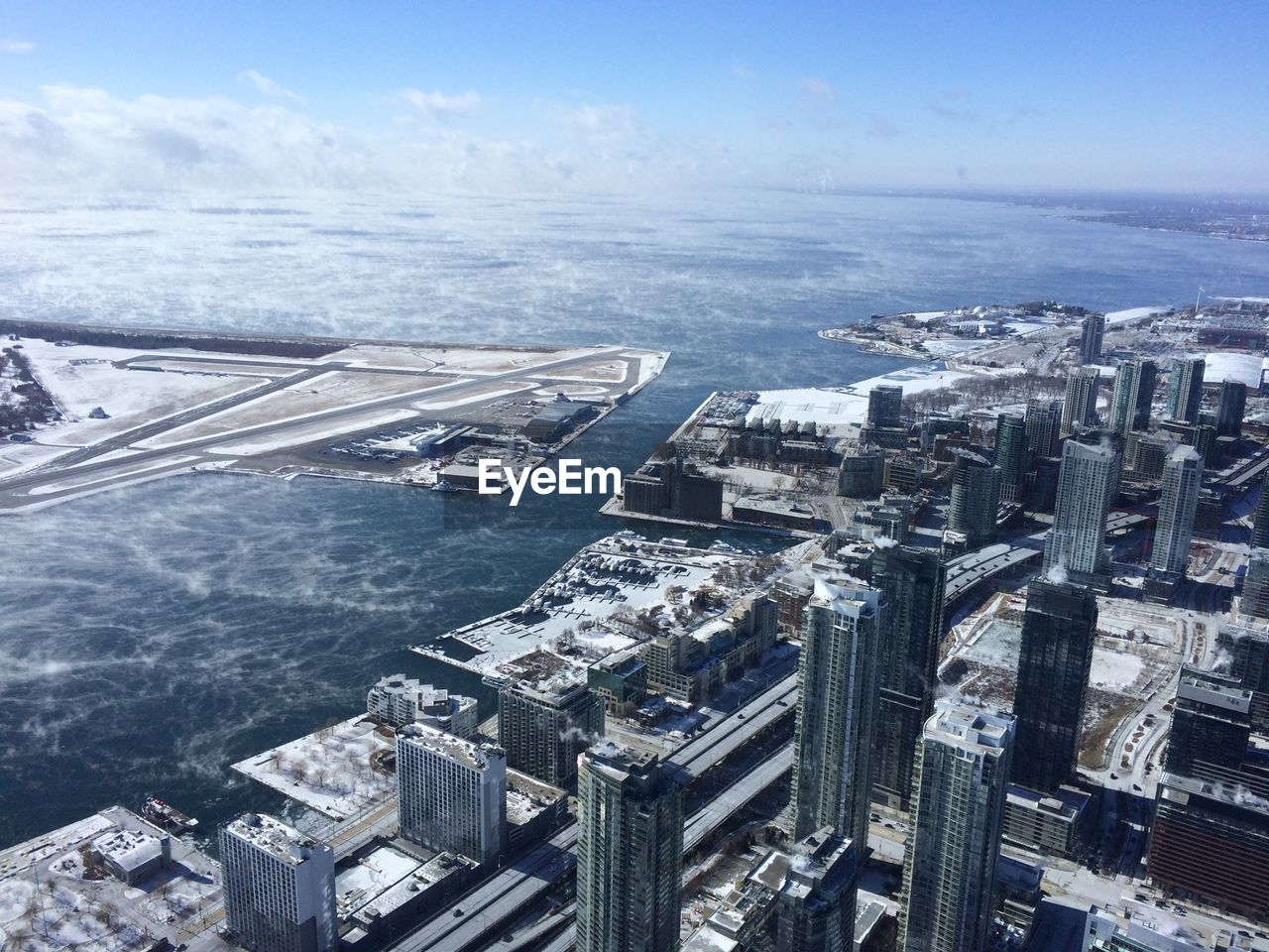 Aerial view of billy bishop toronto city airport and city against sky