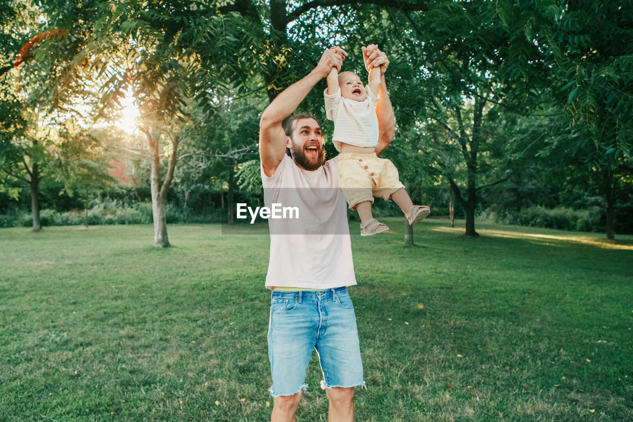 Smiling father playing with son at park