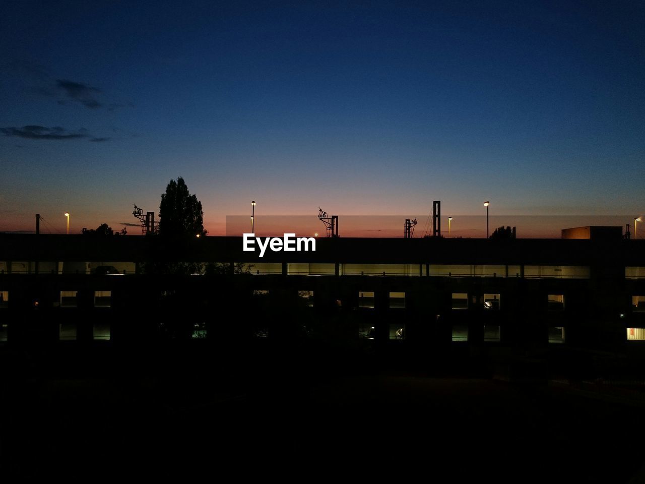 Illuminated railroad station against sky