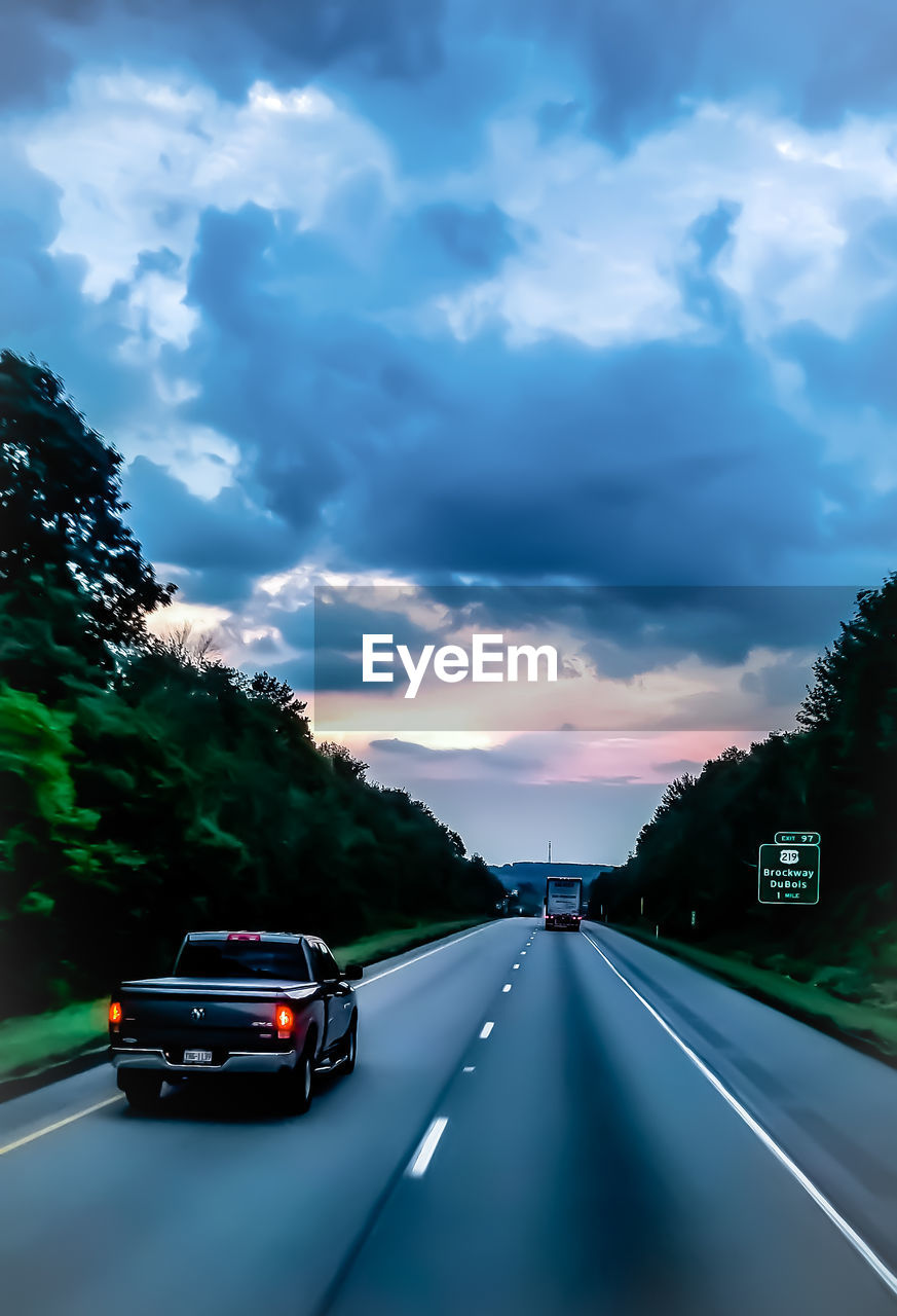 CARS ON HIGHWAY AGAINST SKY