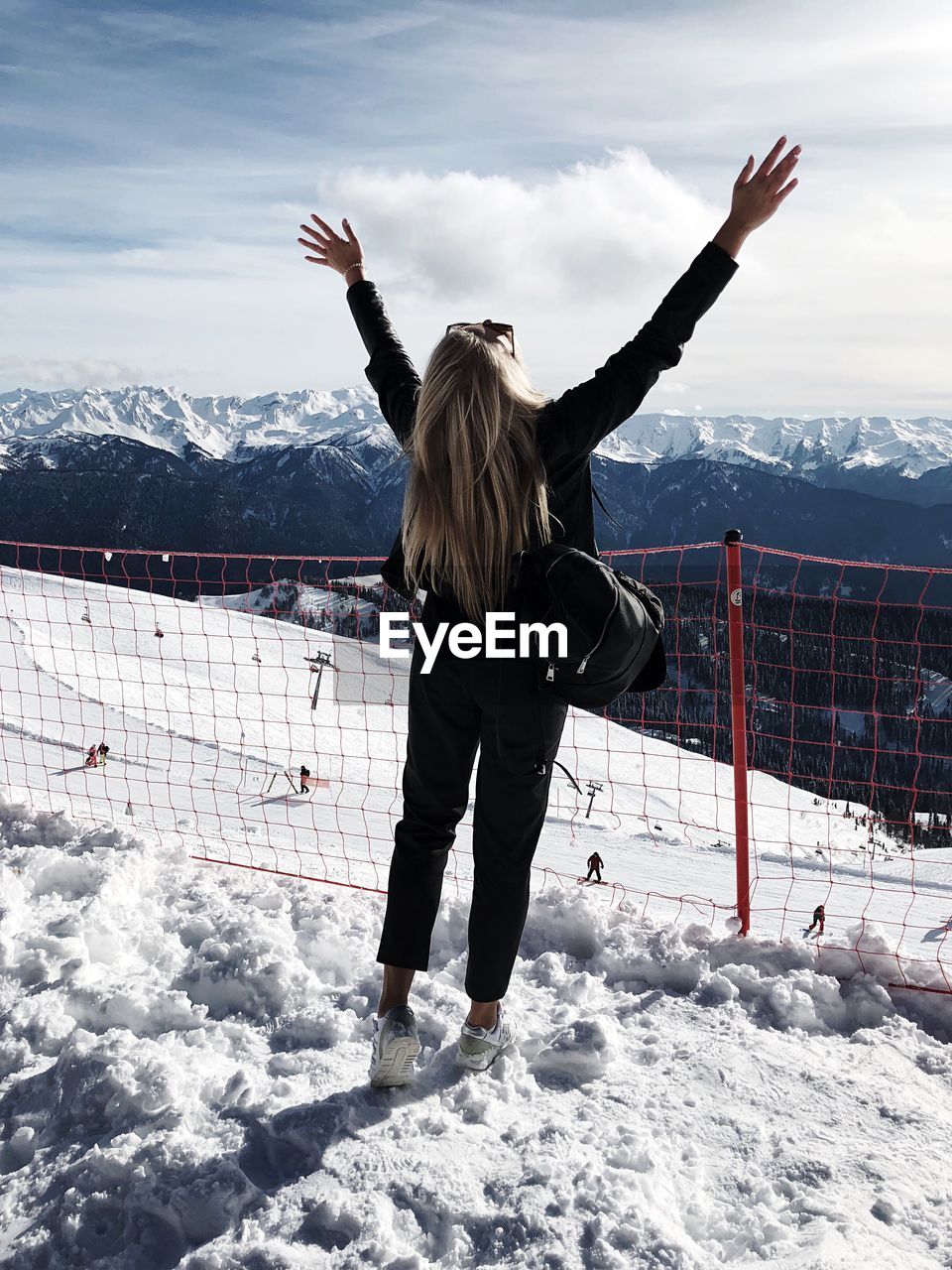 REAR VIEW OF WOMAN WALKING ON SNOW COVERED MOUNTAIN