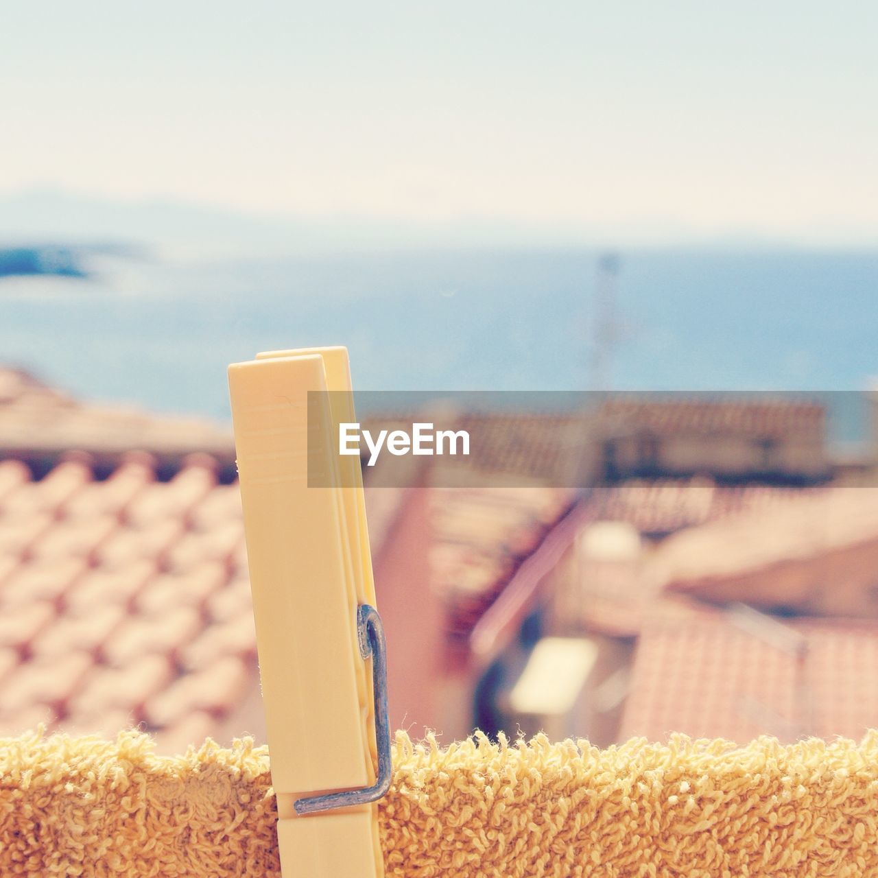 Close- up of clothespin on towel with houses in background