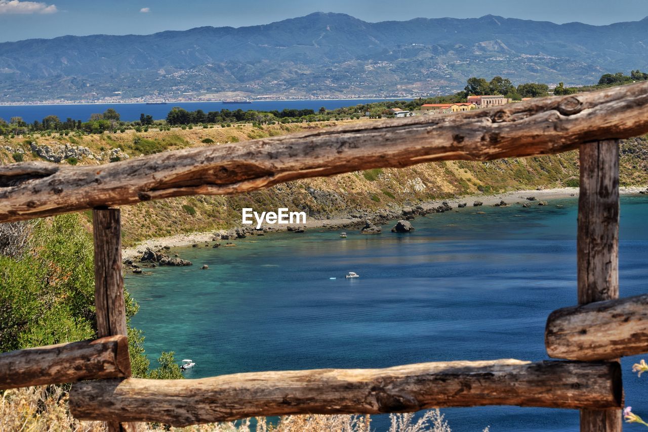 SCENIC VIEW OF SEA AGAINST MOUNTAIN