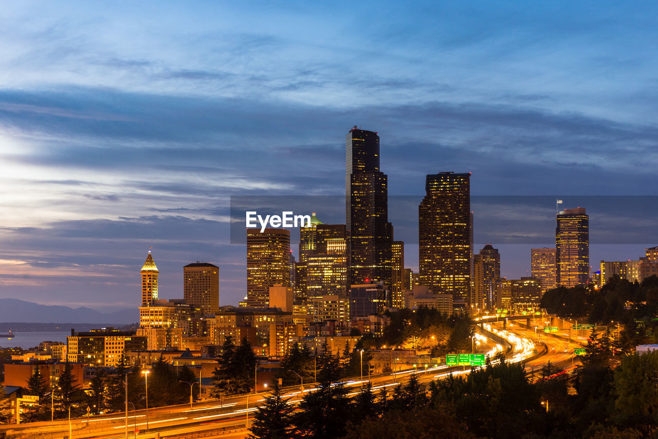 ILLUMINATED BUILDINGS IN CITY AGAINST SKY