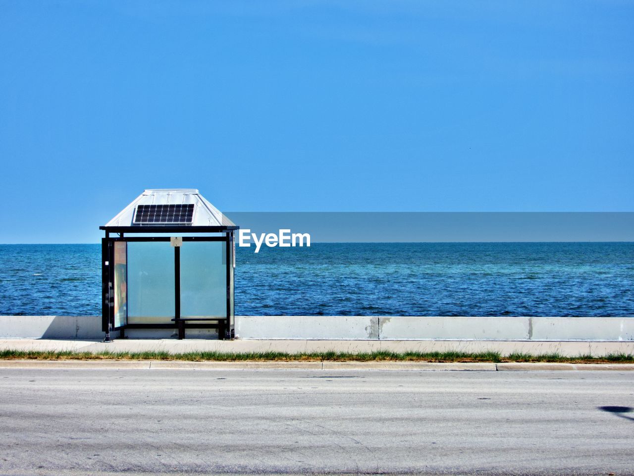 Lifeguard hut on sea against clear blue sky