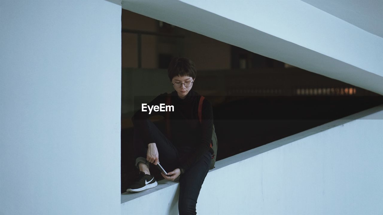 BOY STANDING AGAINST WALL