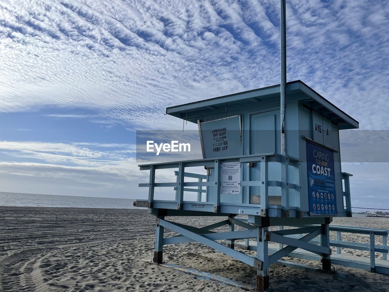 beach, land, sky, sea, architecture, lifeguard hut, hut, built structure, water, cloud, nature, man made structure, sand, security, scenics - nature, protection, beauty in nature, winter, building exterior, no people, tranquility, snow, lifeguard, tower, tranquil scene, blue, ocean, day, building, horizon, outdoors, observation point, horizon over water, non-urban scene, coast, wood, travel destinations, landscape, idyllic, cold temperature