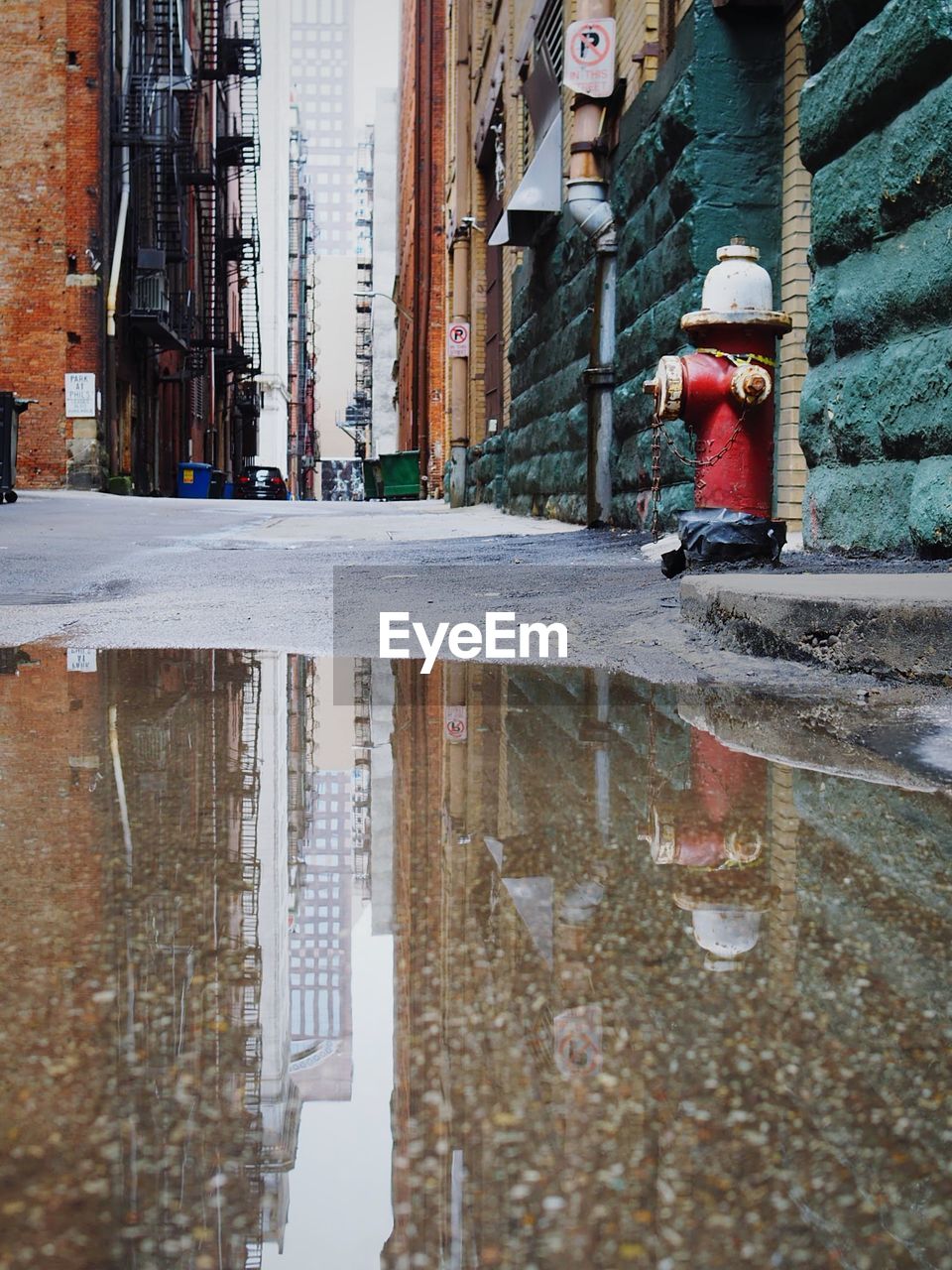 Reflection of building in puddle on street