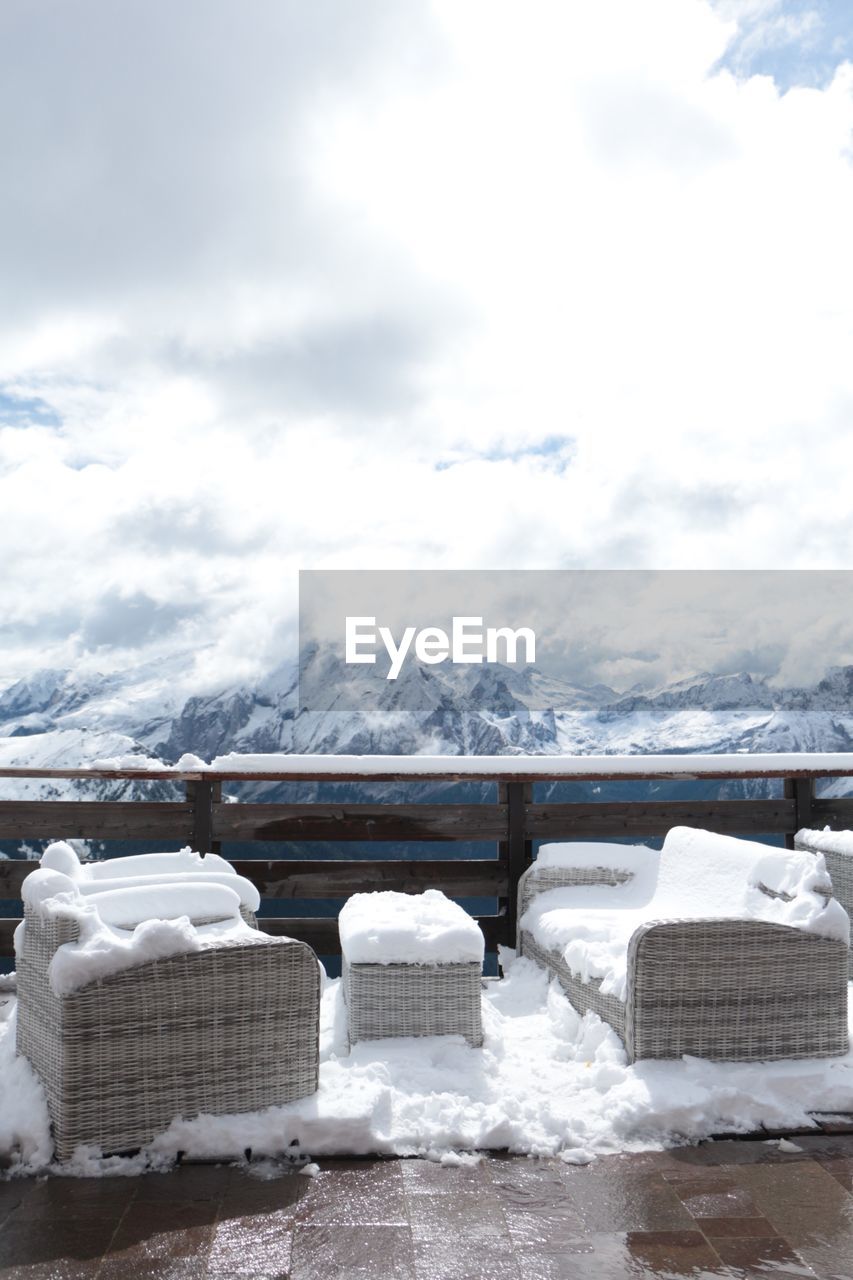 Snow covered seats against sky