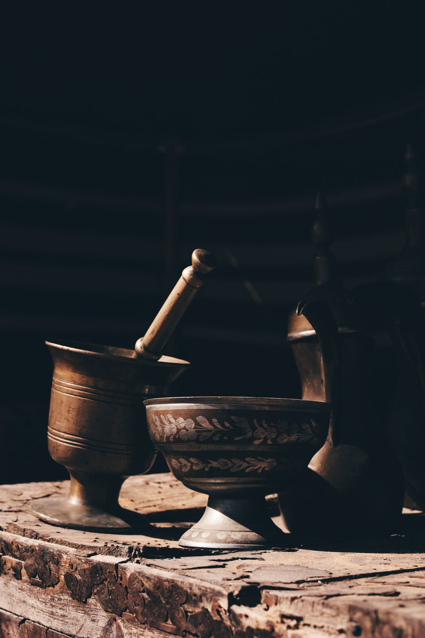 CLOSE-UP OF BOWL ON TABLE AGAINST DARK BACKGROUND