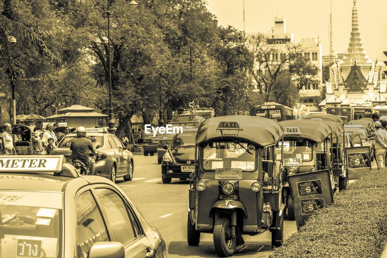 VEHICLES ON ROAD ALONG BUILDINGS