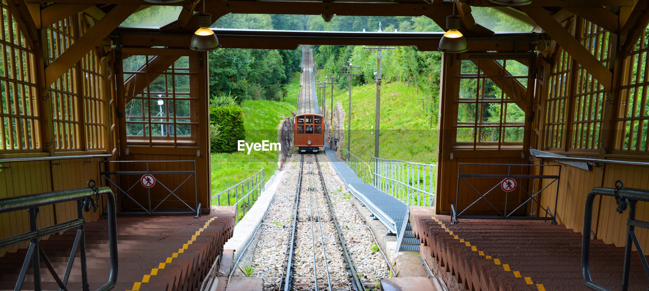 TRAIN ON RAILROAD TRACKS SEEN THROUGH WINDOW