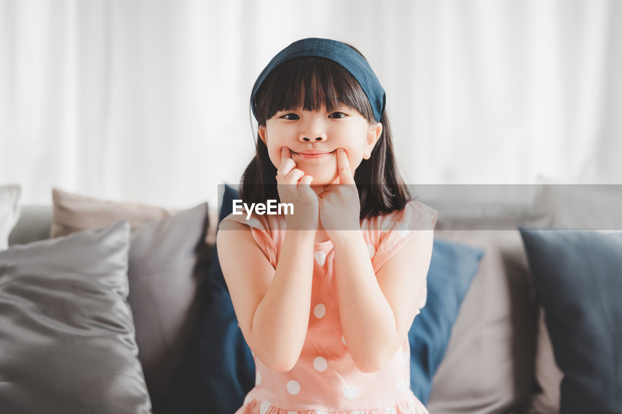 Portrait of woman sitting on sofa at home