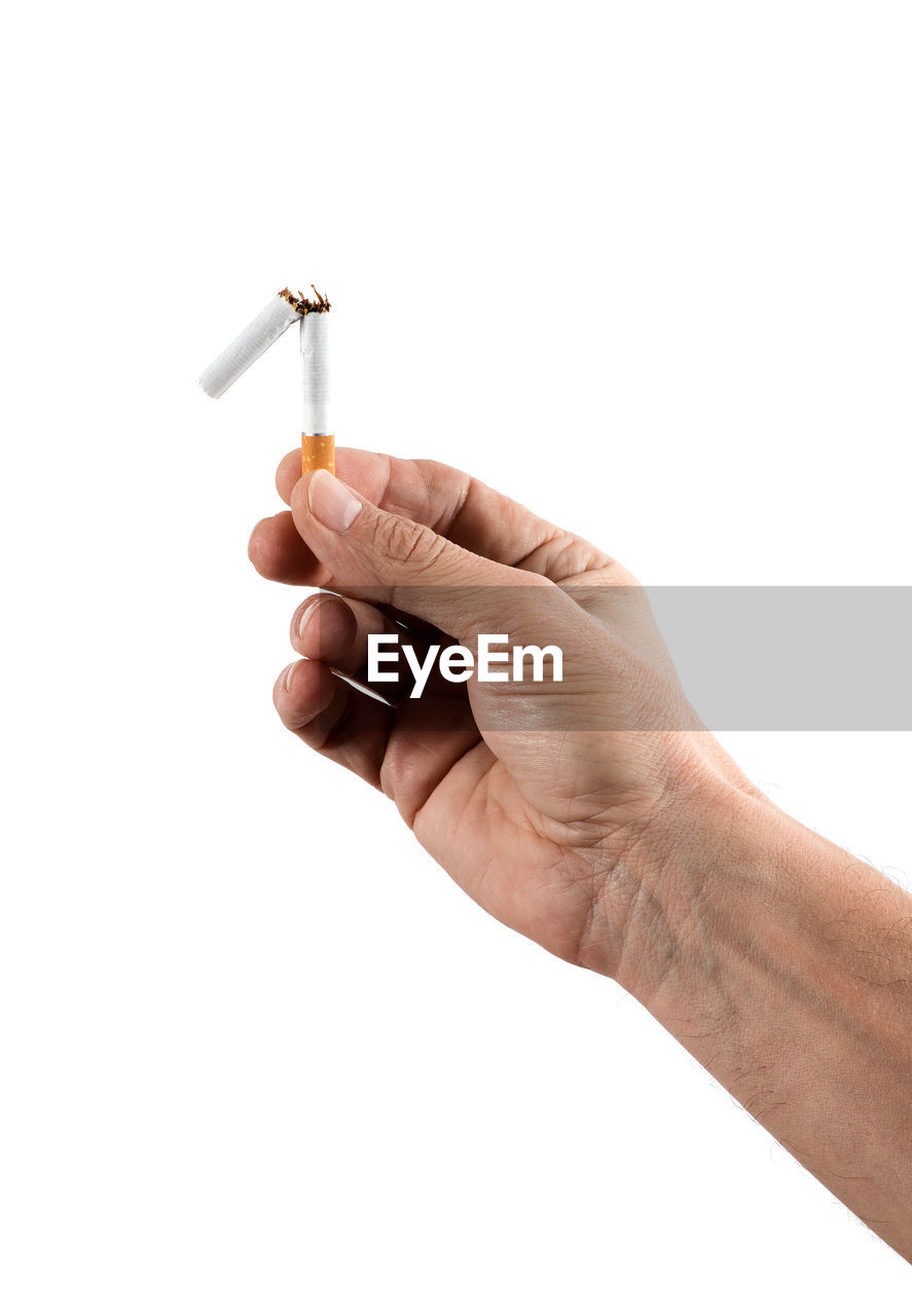 CLOSE-UP OF HUMAN HAND HOLDING CIGARETTE