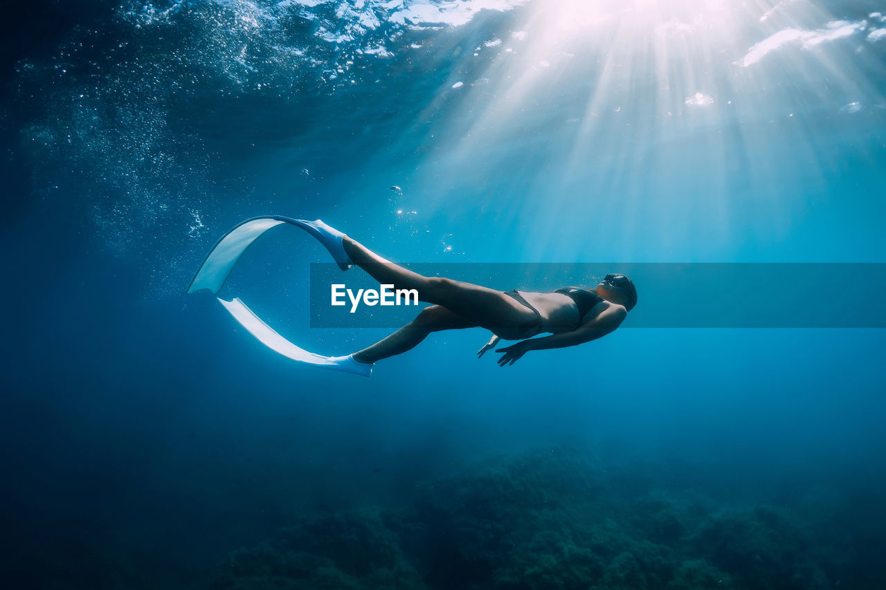 side view of woman swimming in sea