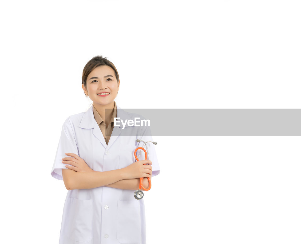 Smiling female doctor standing against white background