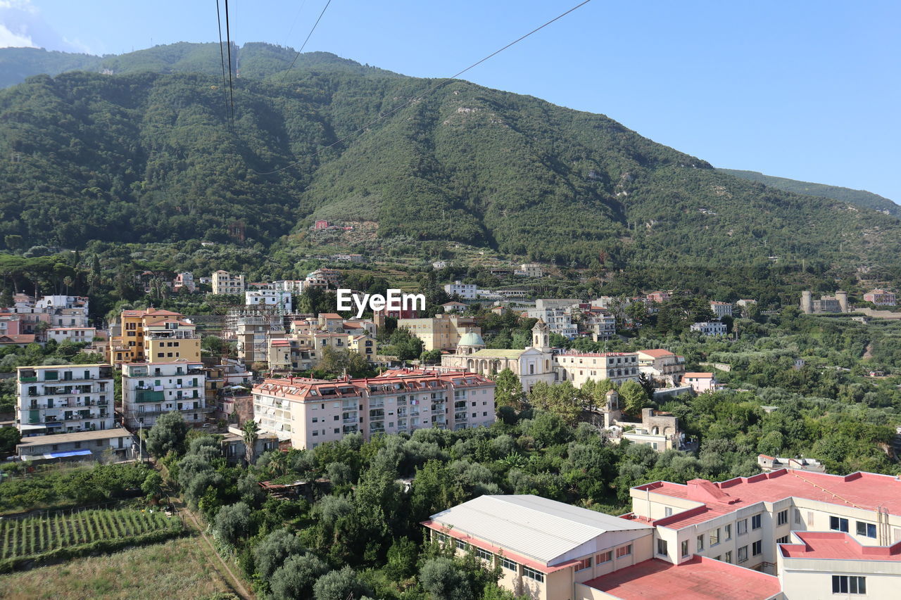 HIGH ANGLE VIEW OF TOWNSCAPE AND TREES AGAINST SKY