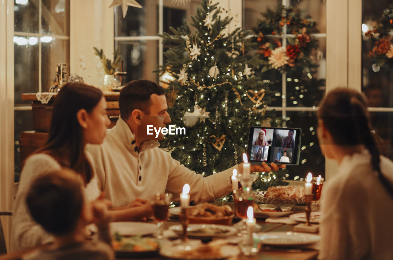 rear view of woman with christmas tree at home