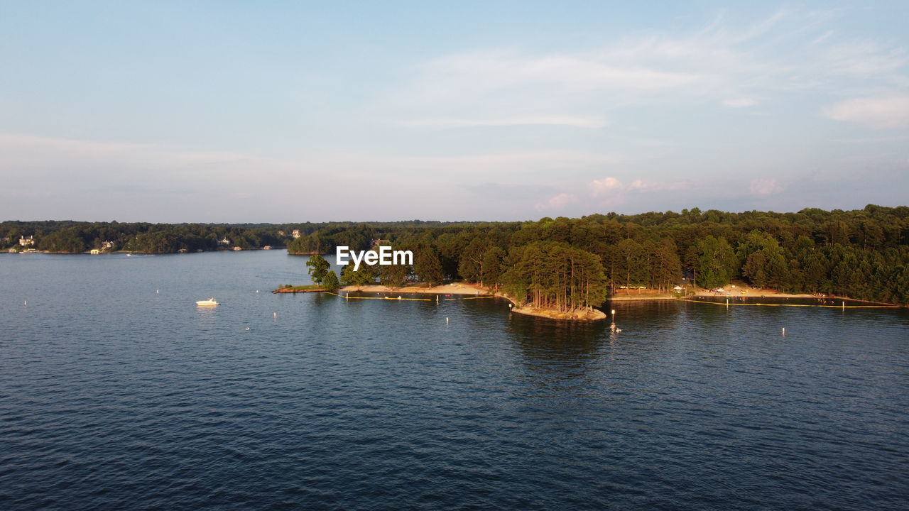 Scenic view from drone of lake and forest against sky