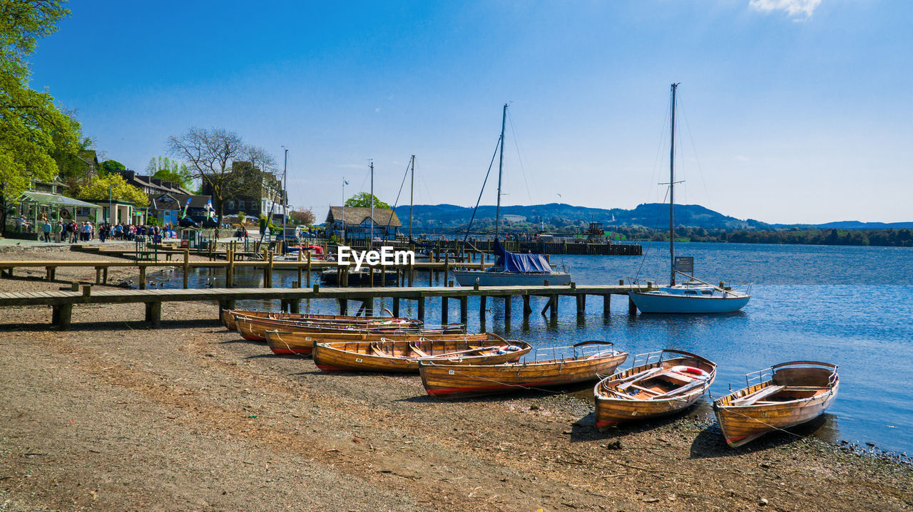 BOATS MOORED AT HARBOR BY SEA AGAINST SKY