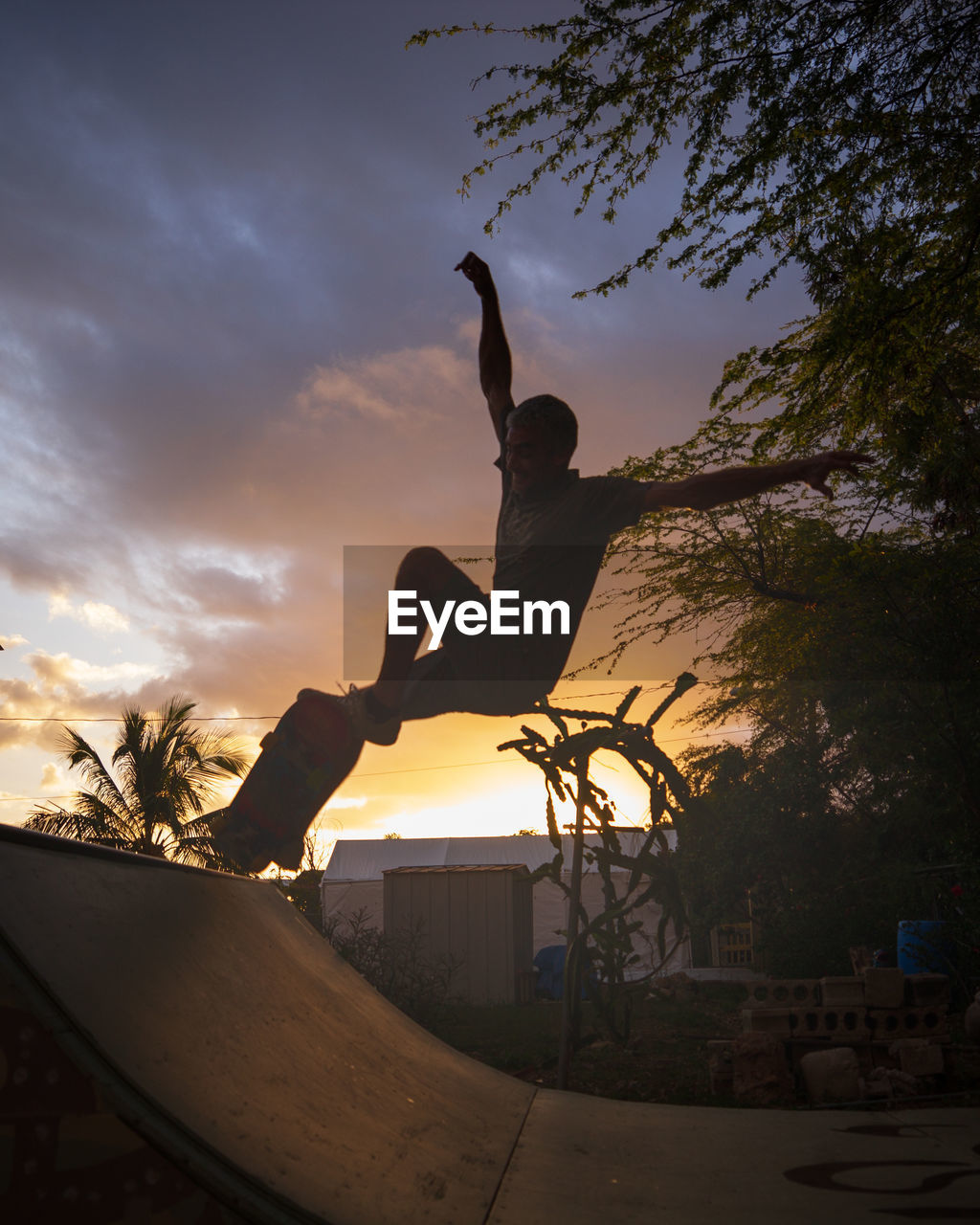 Low angle view of silhouette man jumping against sky