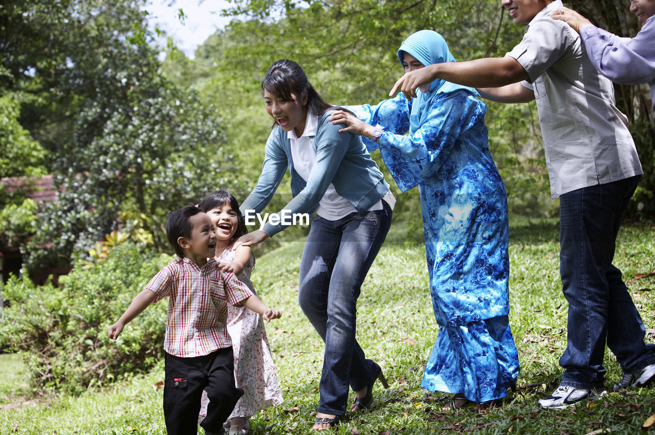 Portrait of smiling family playing on grass