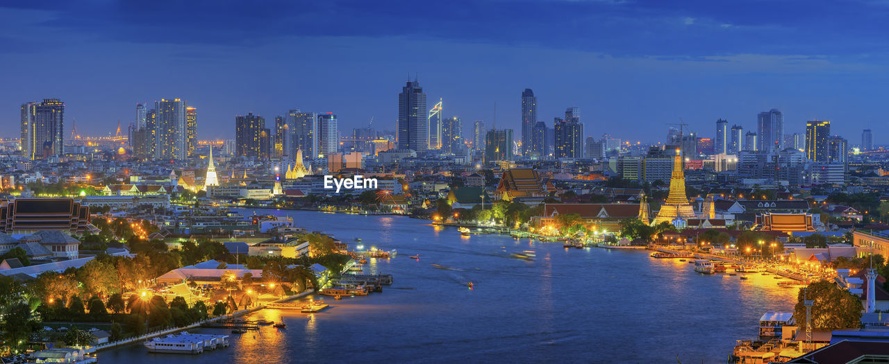 Illuminated buildings in city at dusk