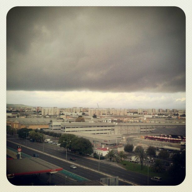 VIEW OF CITYSCAPE AGAINST CLOUDY SKY