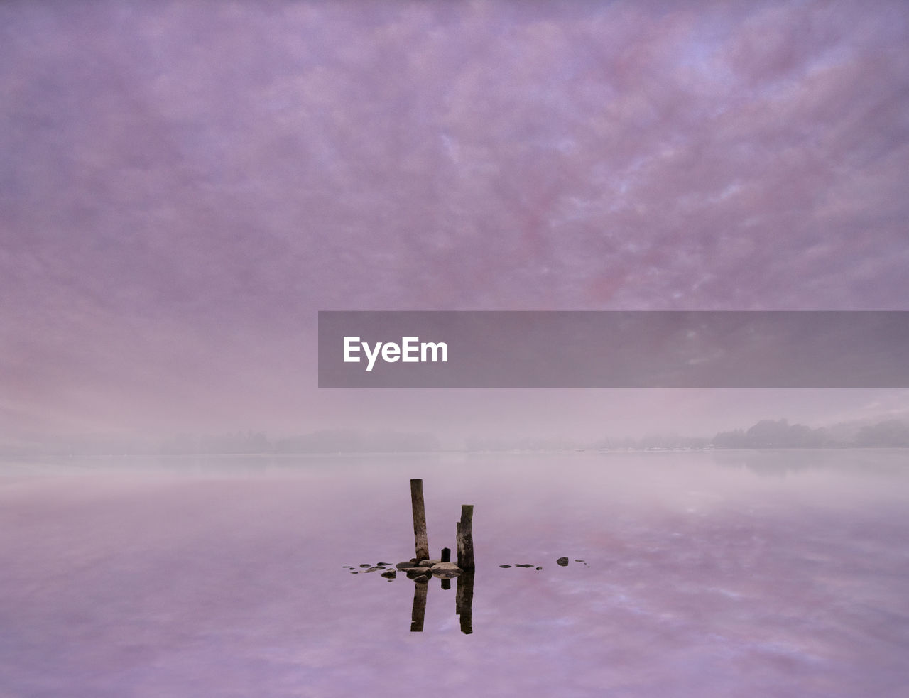 SCENIC VIEW OF WOODEN POST IN LAKE AGAINST SKY