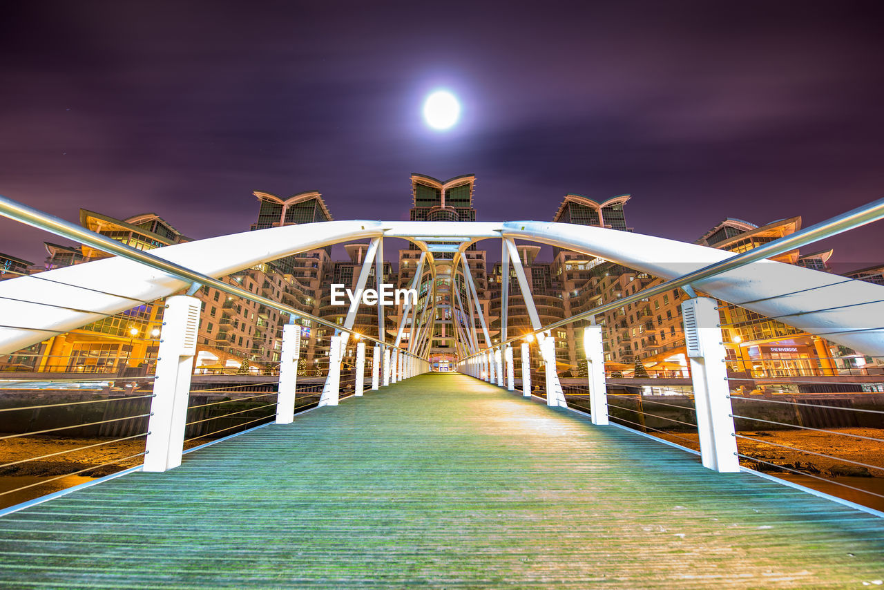 Low angle view of bridge in city at night