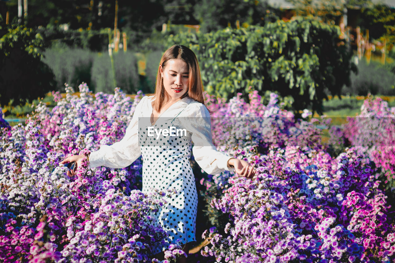 Woman standing on purple flowering plants