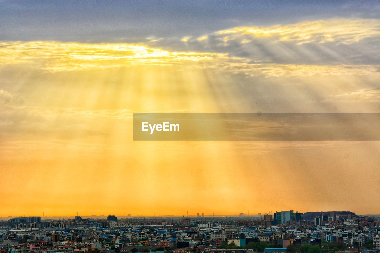 Aerial view of buildings against sky during sunset