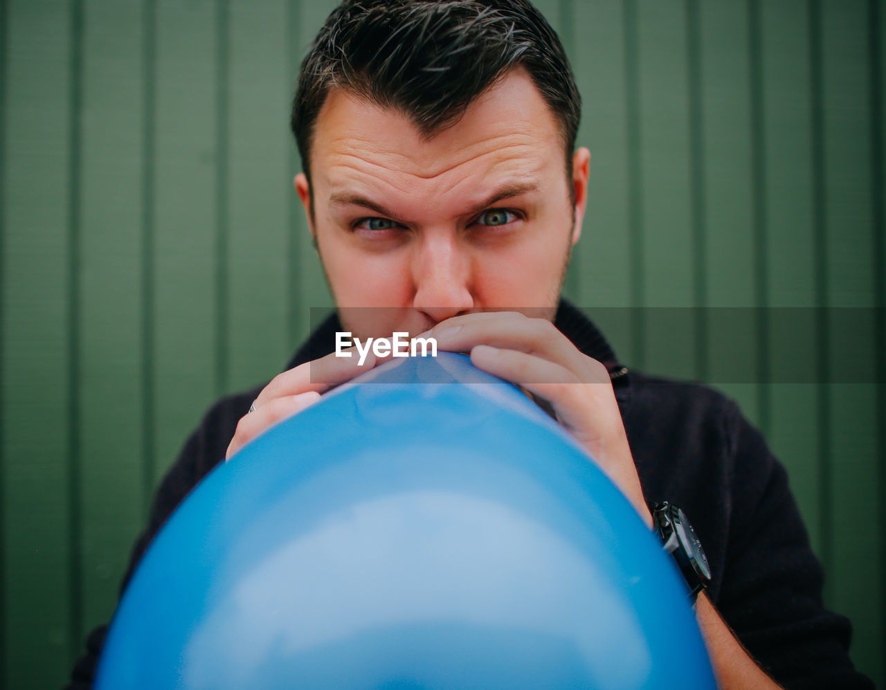 Portrait of man blowing balloon