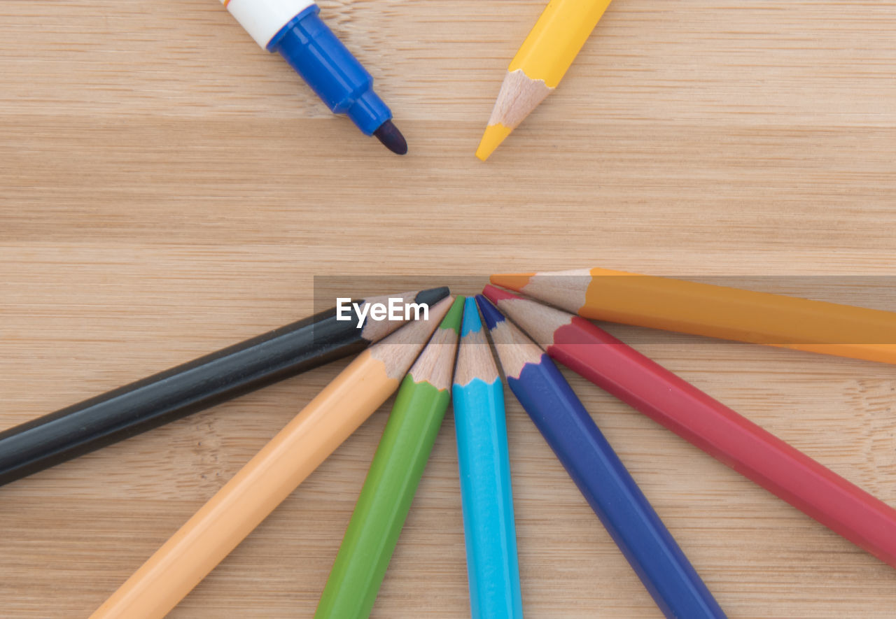 HIGH ANGLE VIEW OF PENCILS ON WOODEN TABLE