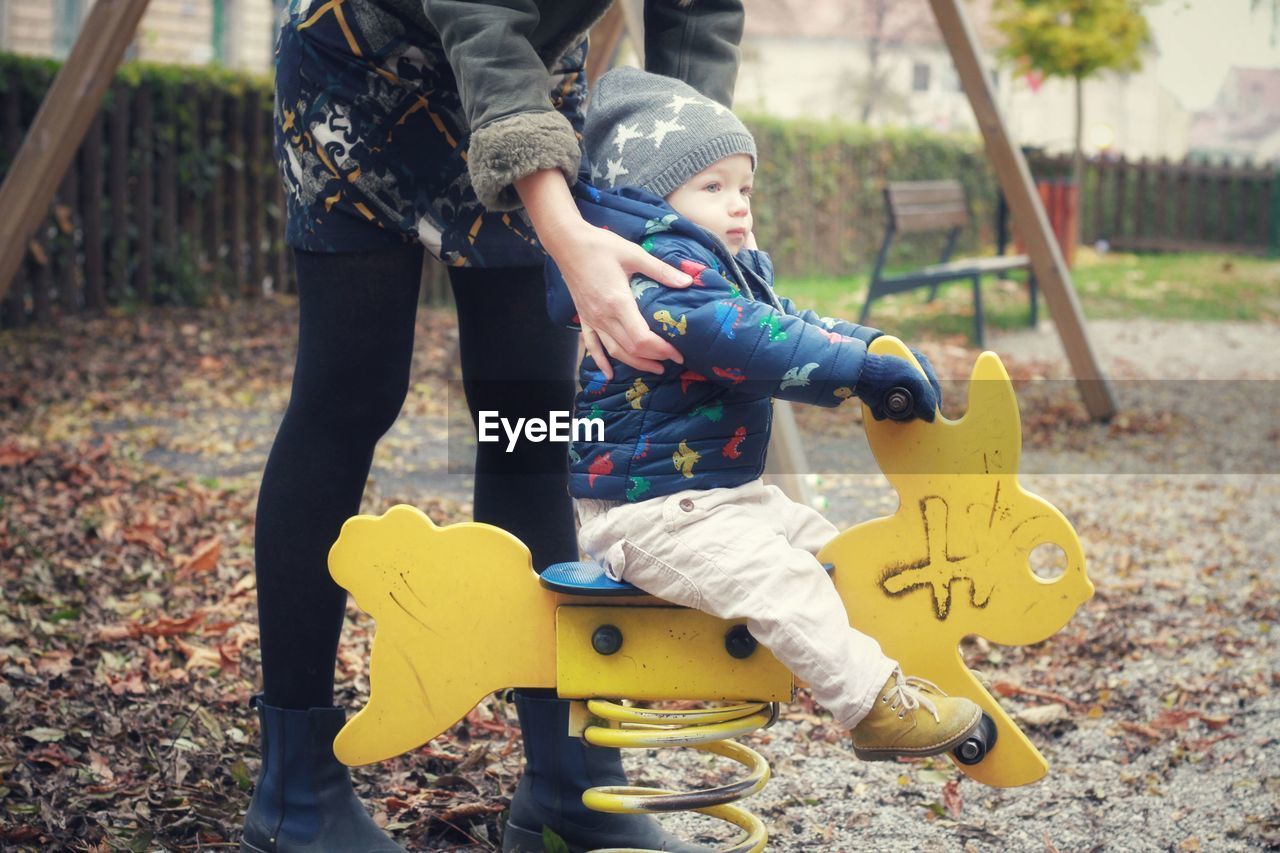 Baby boy playing in park with mother