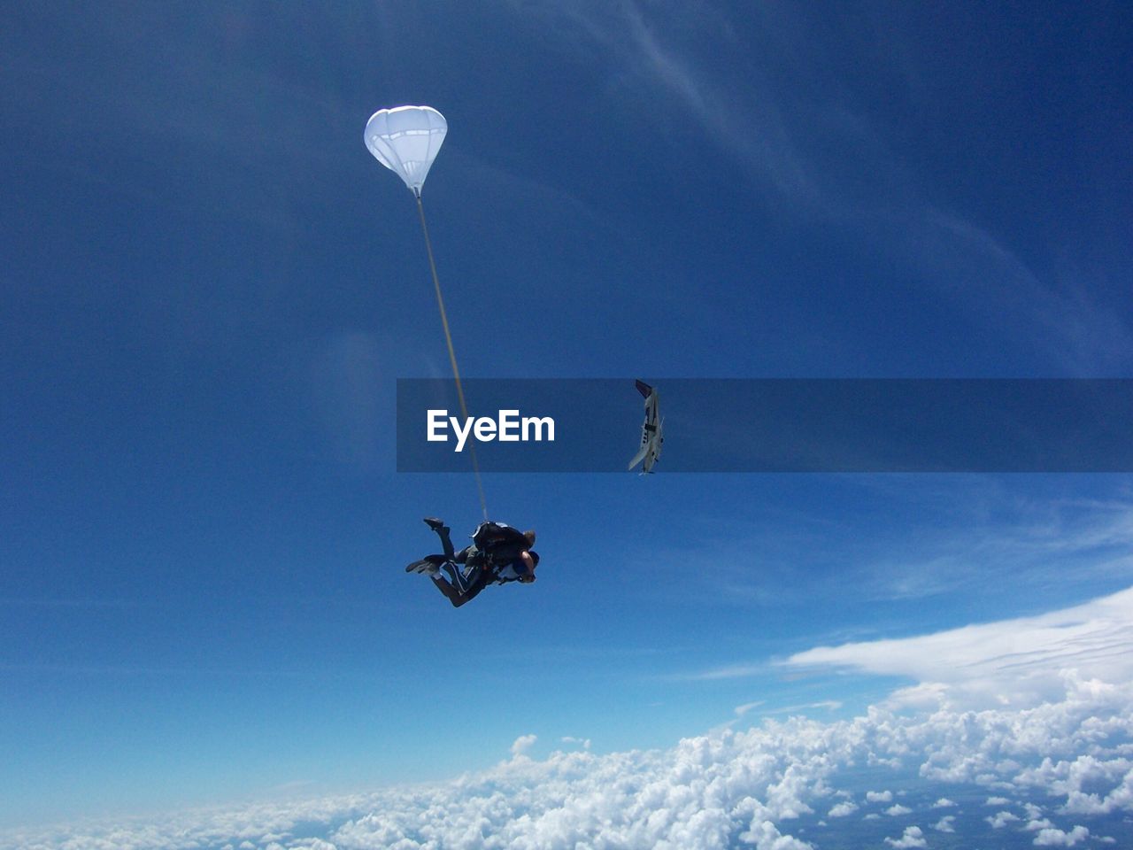 Low angle view of man paragliding against sky