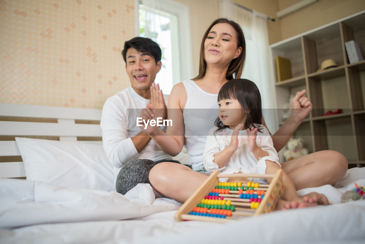 Happy family playing on bed at home