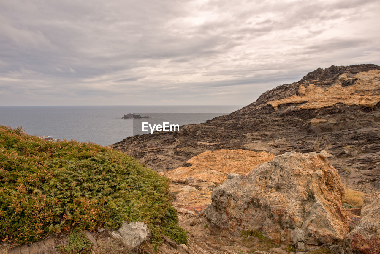 Scenic view of sea and mountains against sky