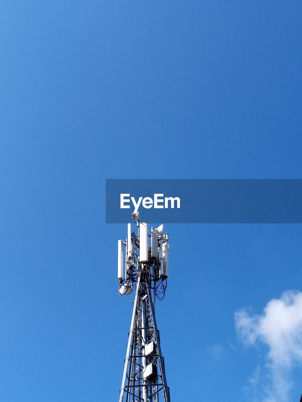 Low angle view of communications tower against blue sky