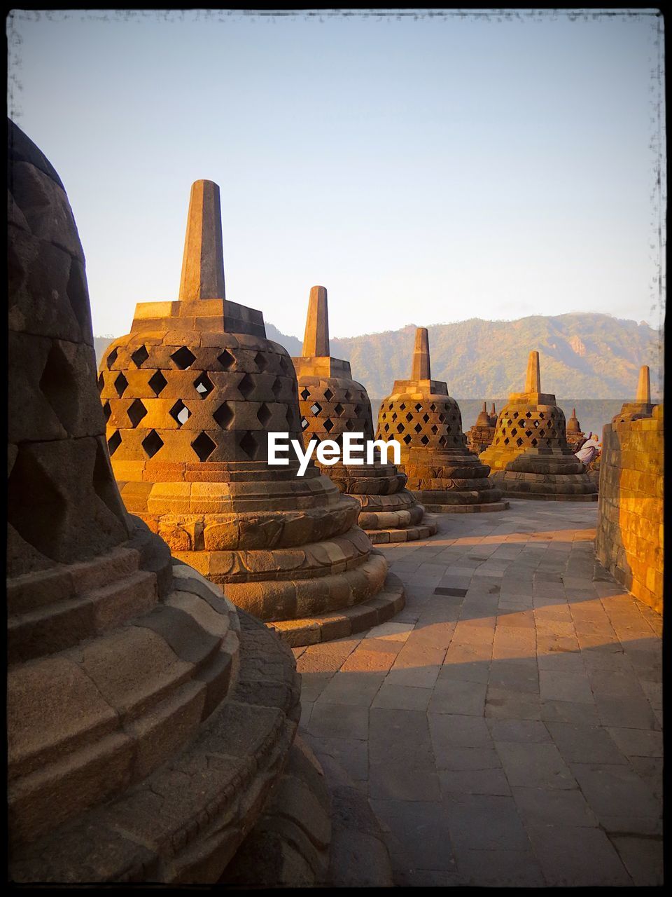 Stupas at borobudur temple against clear sky at morning