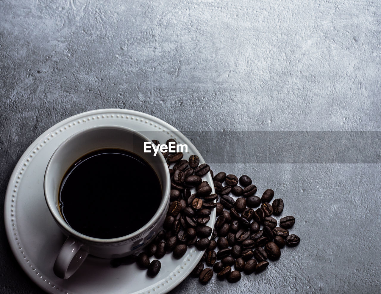 HIGH ANGLE VIEW OF COFFEE CUP ON TABLE WITH BLACK BACKGROUND