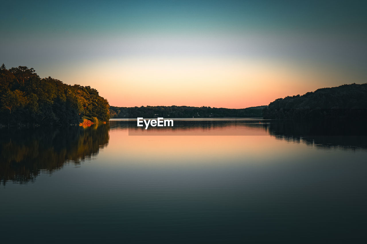 Landscape of peaceful area covered with trees and reflecting in still water