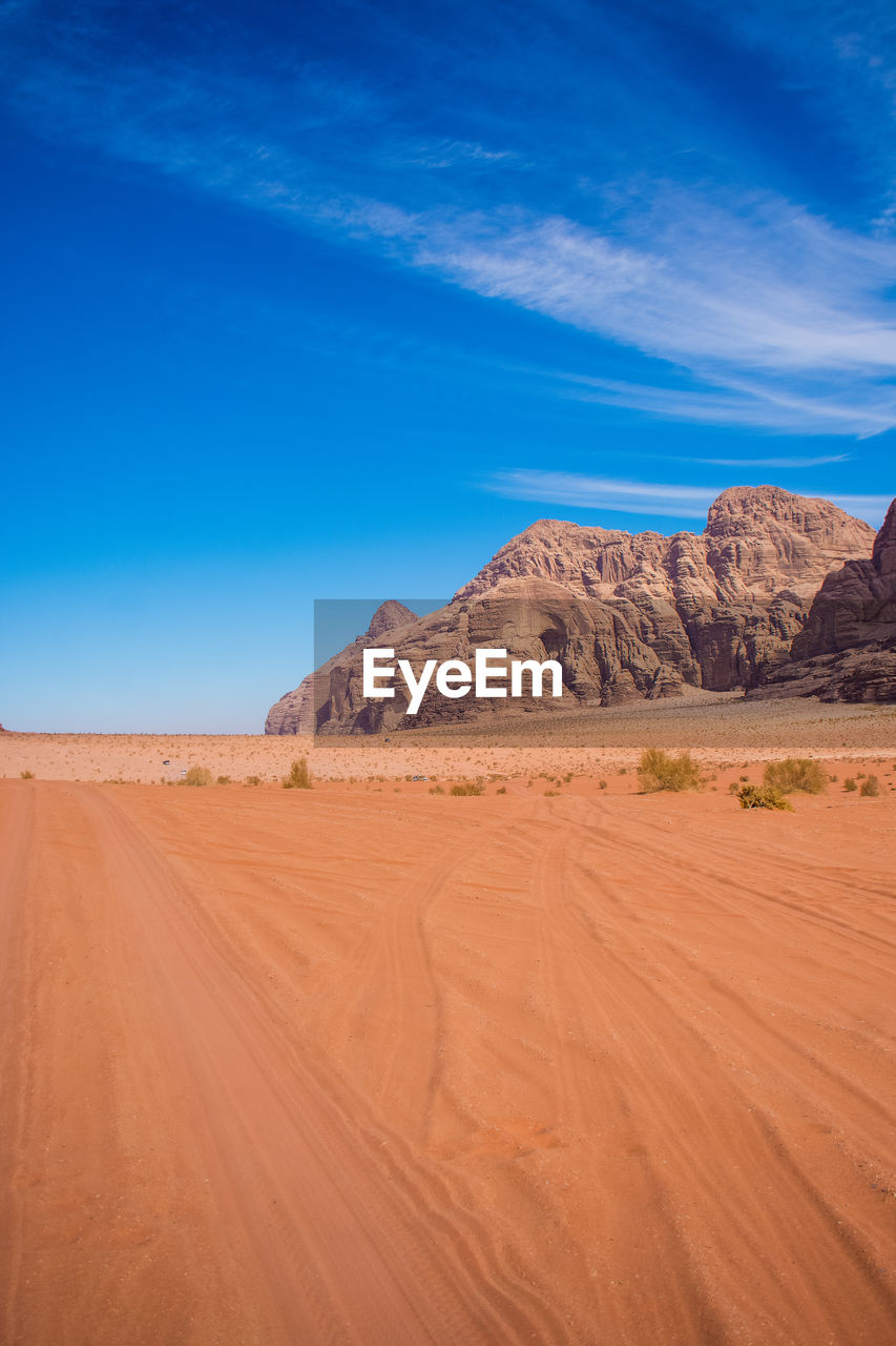 Scenic view of desert against blue sky