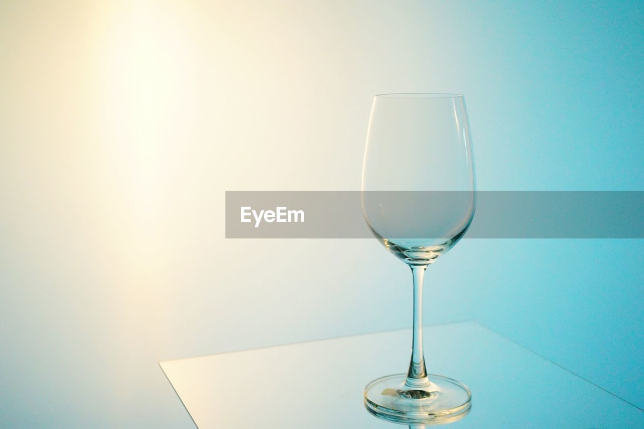 Close-up of wineglass on table against sky