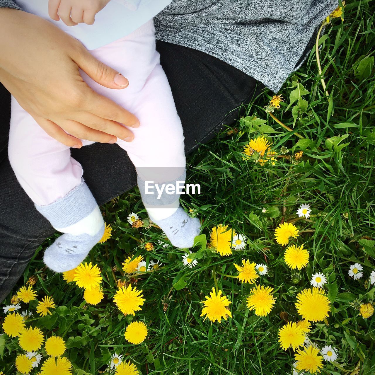 LOW SECTION OF WOMAN WALKING ON GRASSY FIELD