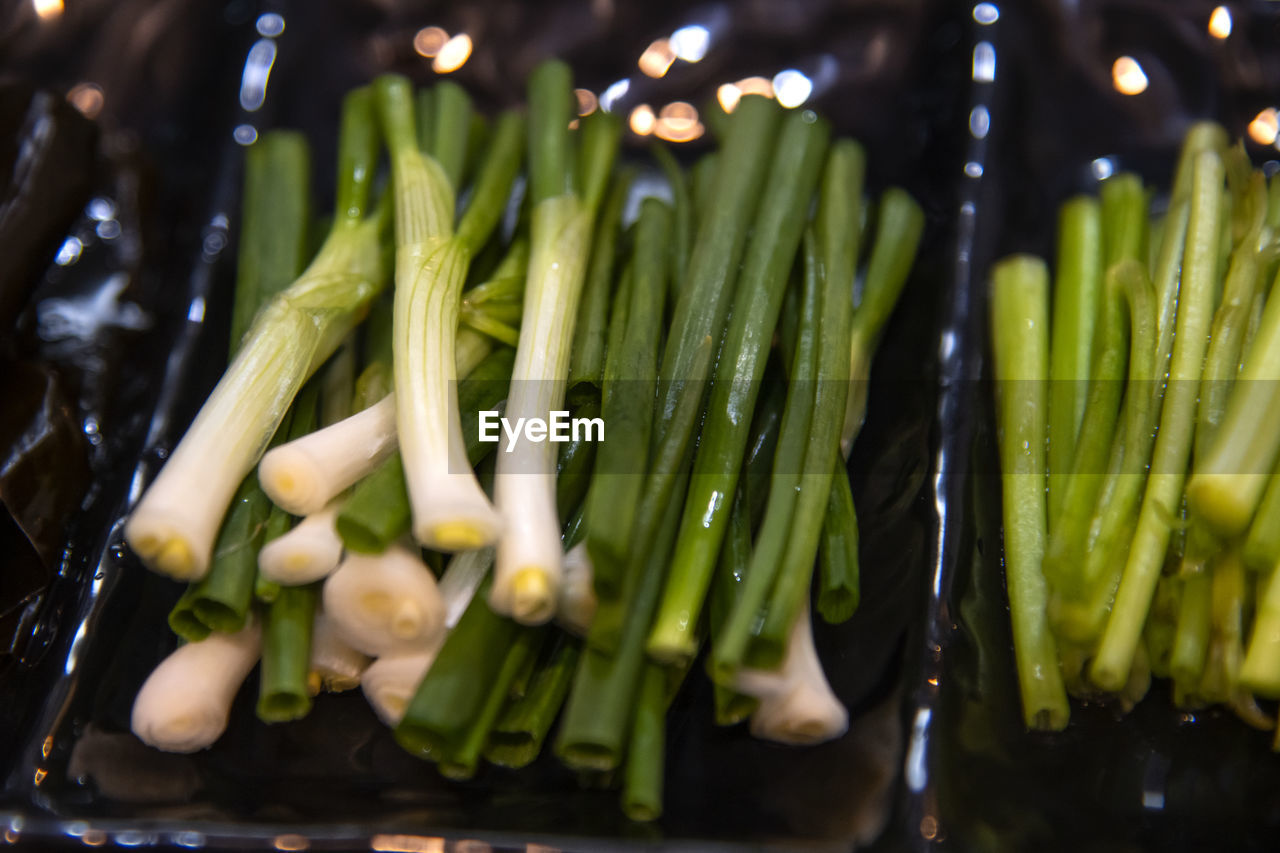 High angle view of chopped vegetables of green onion and water parsley on table