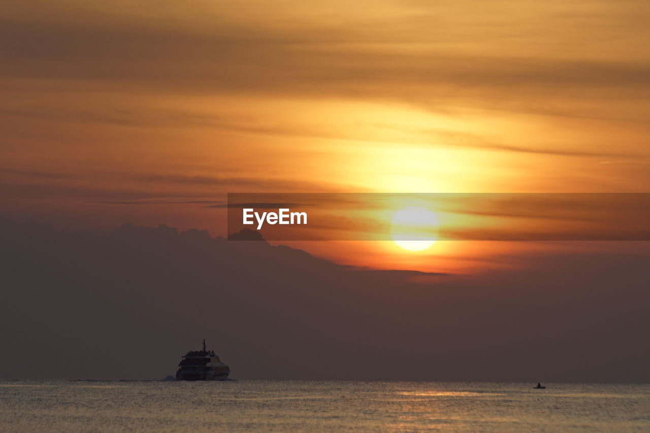 SILHOUETTE BOAT IN SEA AGAINST SKY DURING SUNSET