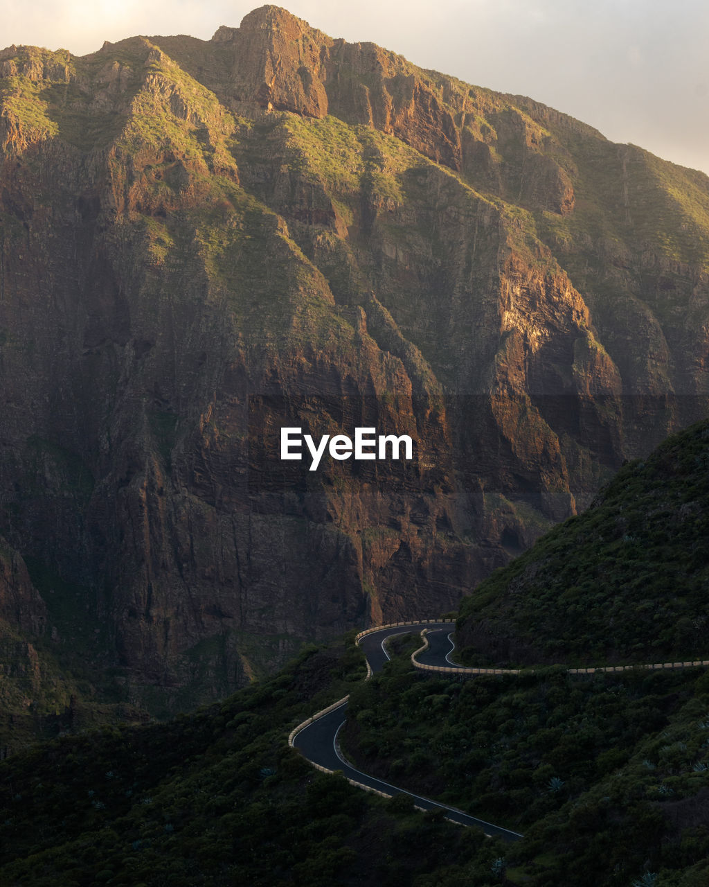 Scenic view of road by mountains against sky