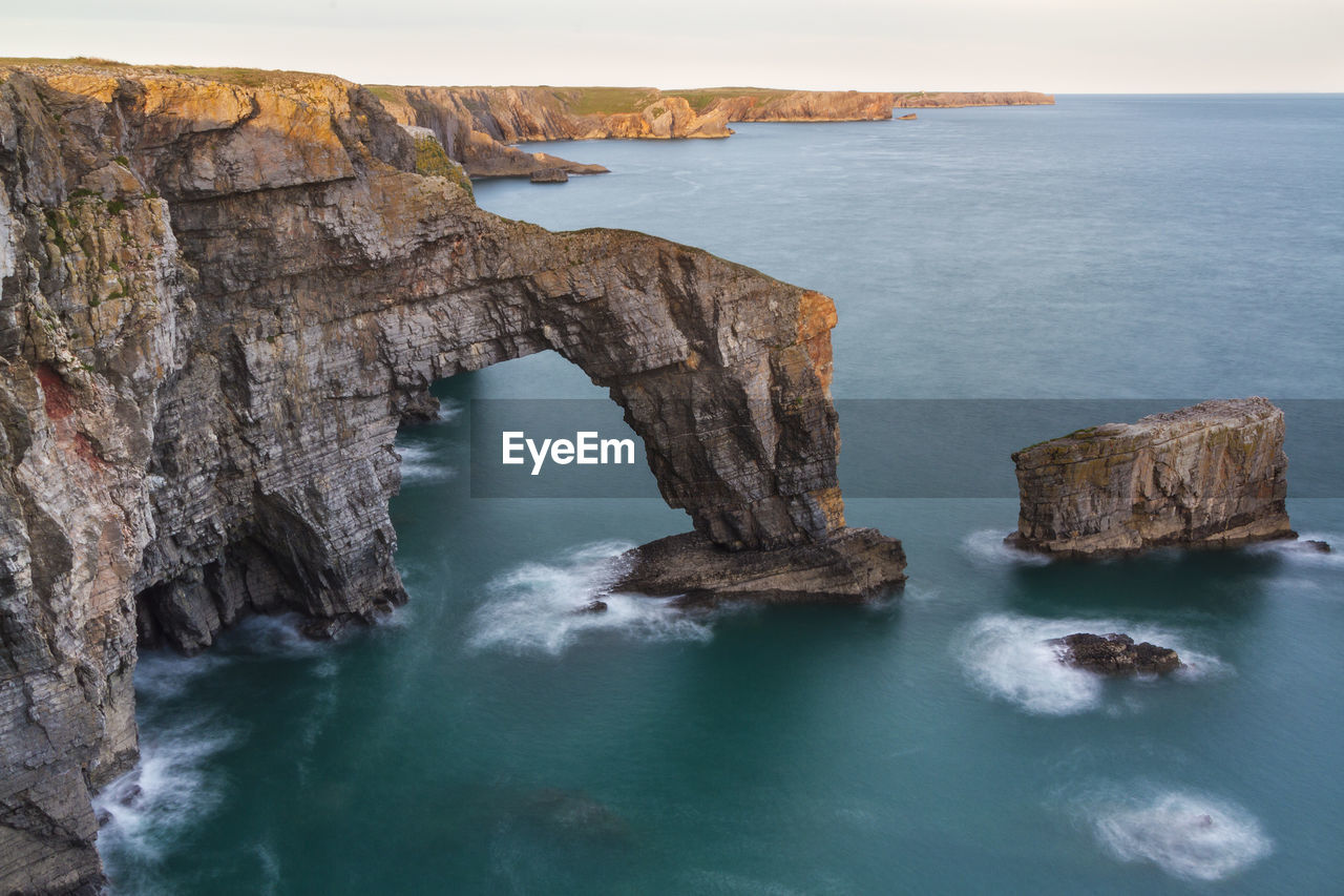 Scenic view of rock formation in sea against sky