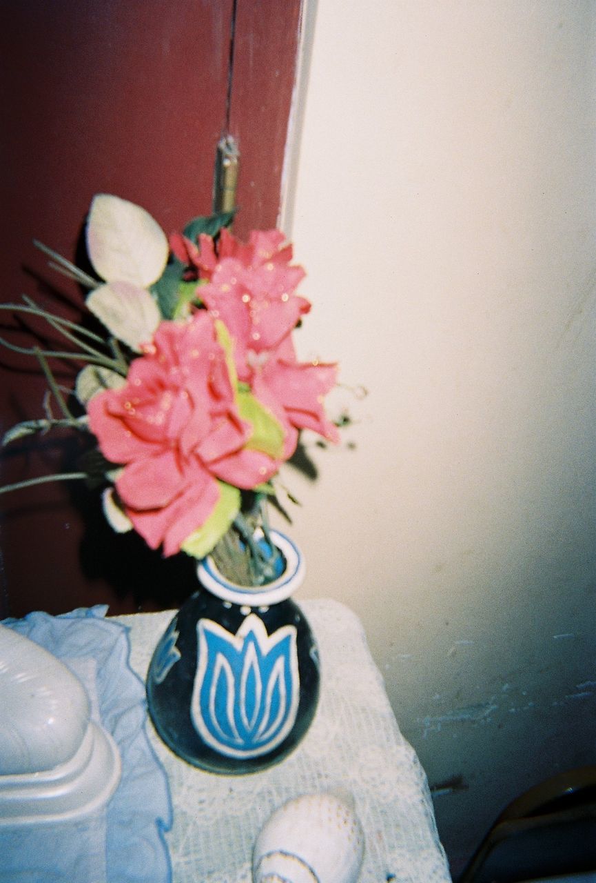 CLOSE-UP OF FLOWER VASE ON TABLE AT HOME